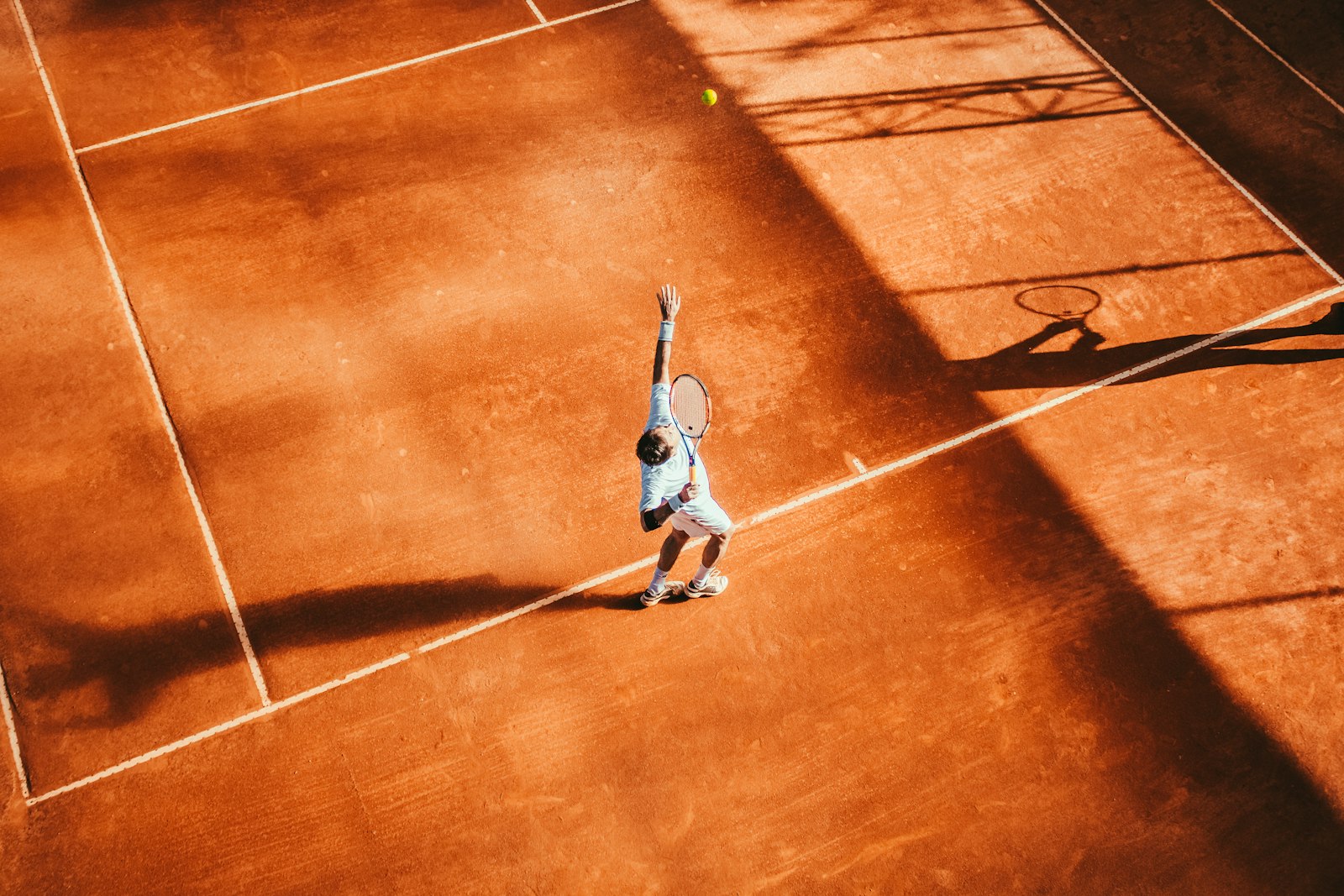 Aufschlag beim Tennistraining auf dem Sandplatz